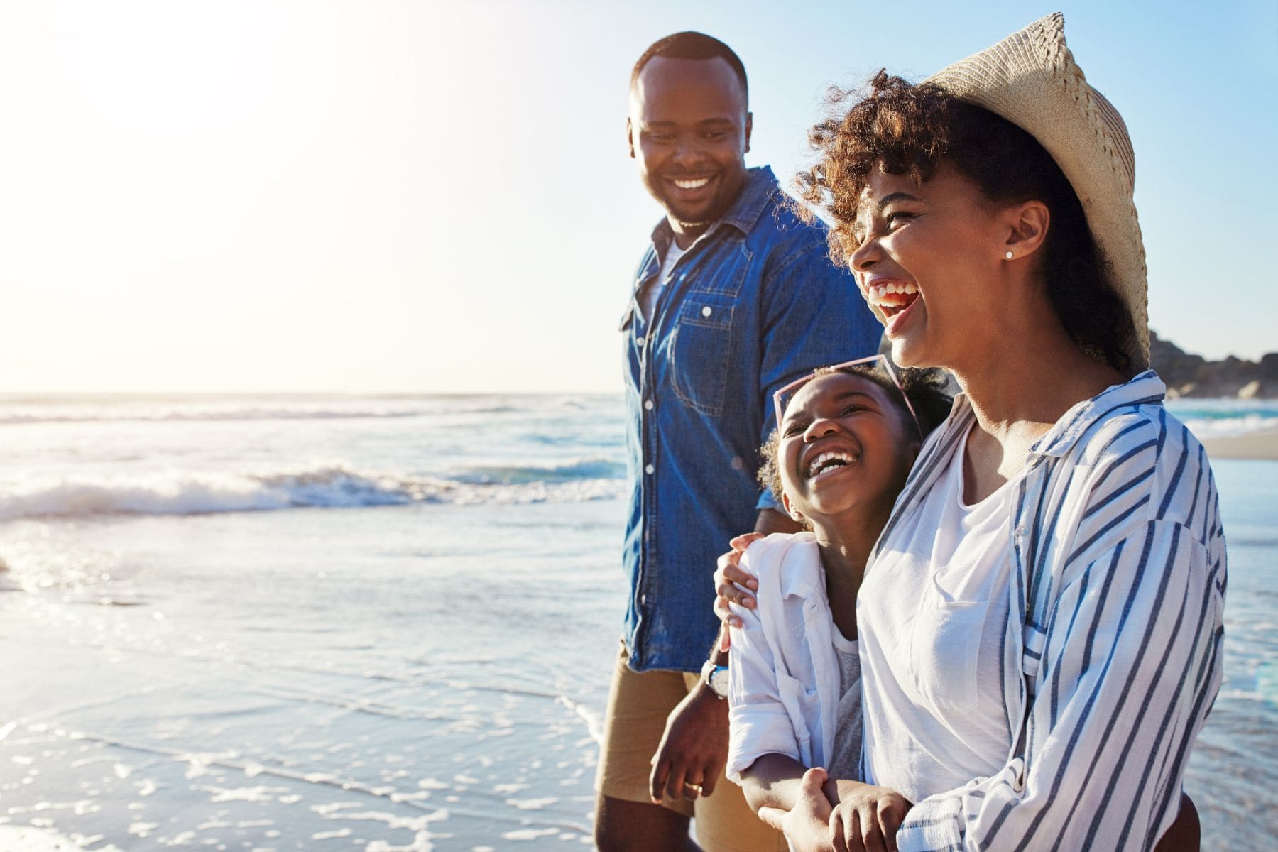 Family of four enjoying beach vacation together in casual clothing