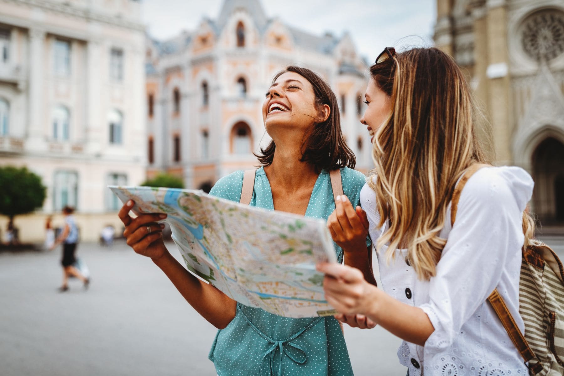 Two women consulting a map while sightseeing in a European city square