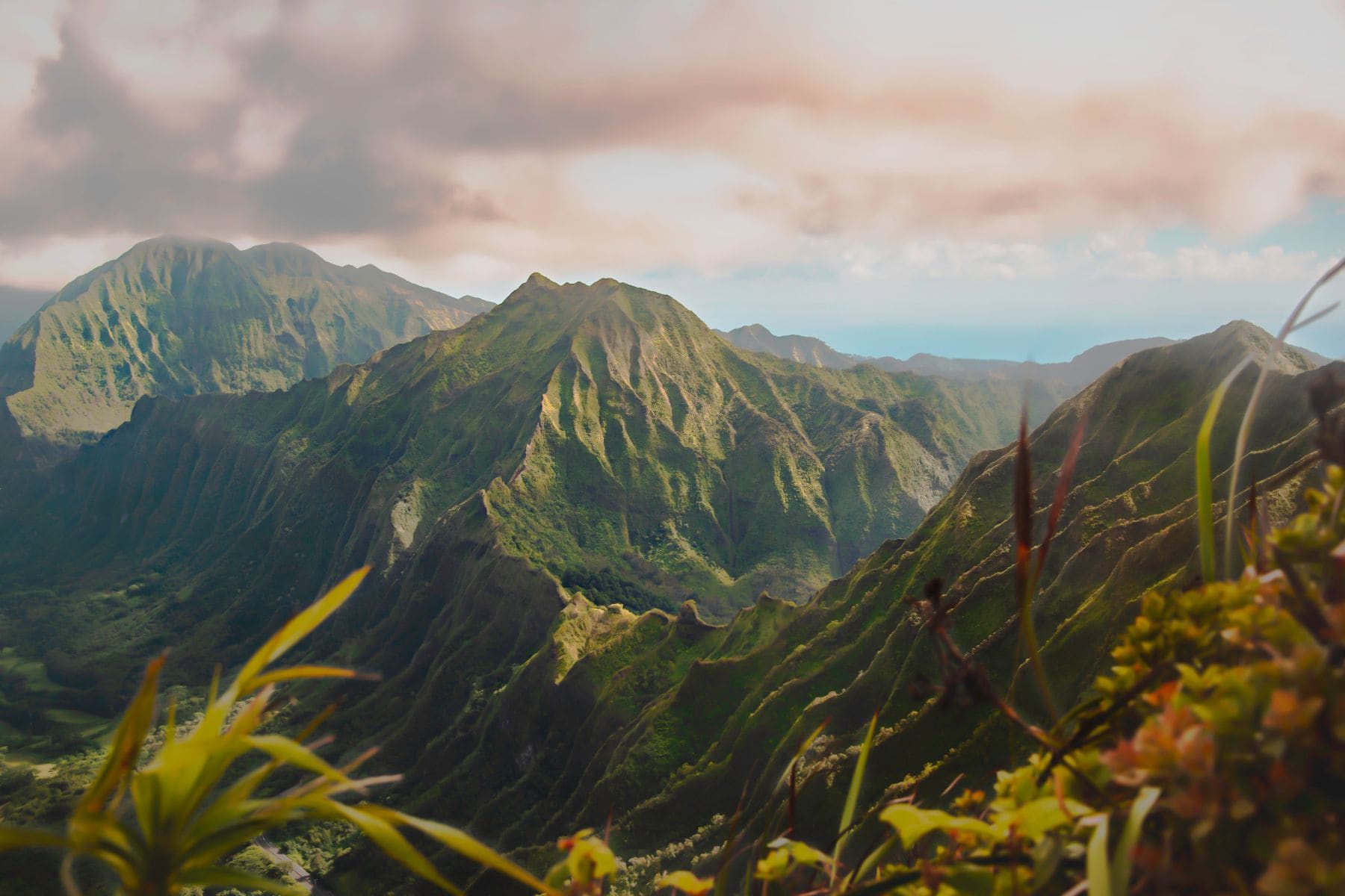 Verdant Hawaiian mountain valley with dramatic ridged peaks and lush vegetation in foreground